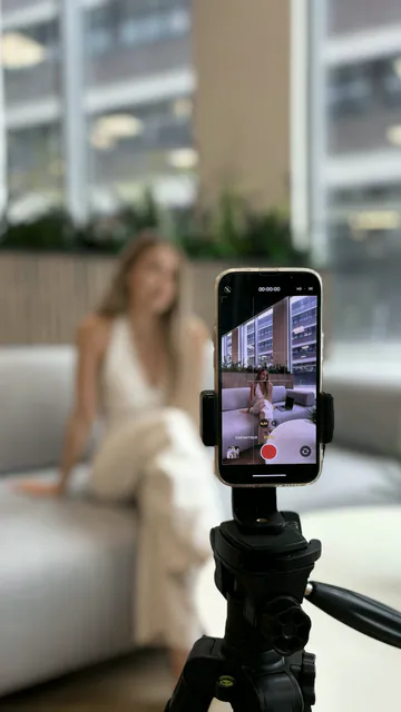 Creator filming themselves in vertical video with a phone on a tripod