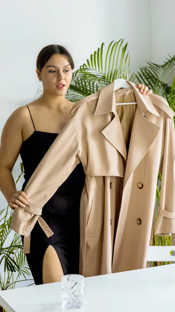 Creator presenting a trench coat in front of a ring light